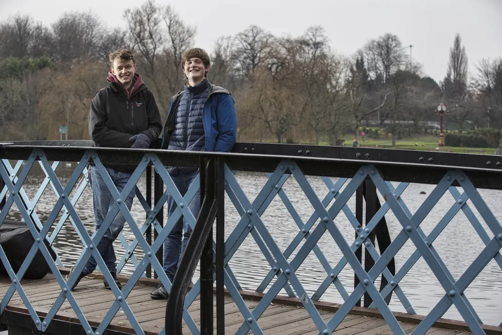 Roo and Neil standing on a lattice bridge