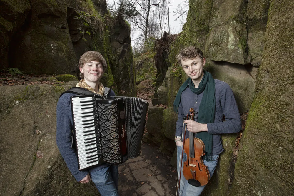 Neil with accordion and Roo with fiddle in a rocky glen